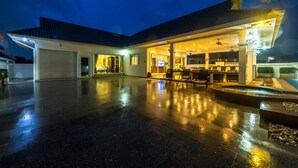 A spacious outdoor area with a covered patio, a pool, and a well-lit entrance. - Private 3 Bedroom Pool Villa PP10 (Hua Hin)