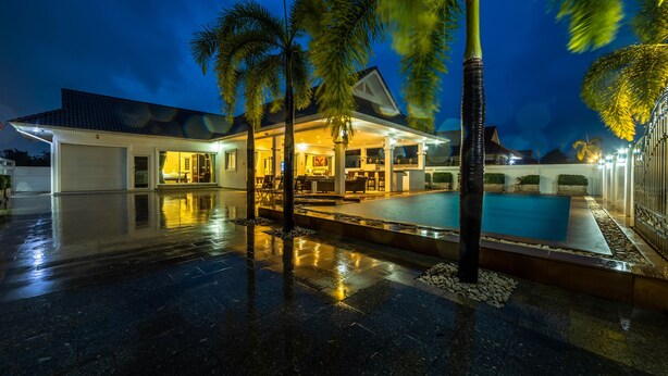 A modern house with a swimming pool, a covered patio, and palm trees. - Private 3 Bedroom Pool Villa PP10 (Hua Hin)