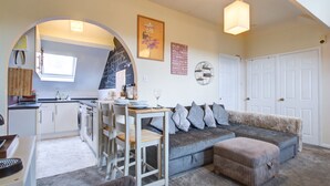 A compact living space with a kitchenette, a dining area, and a sofa. - Entire Artistic Open-plan Top Floor Apartment (Westcliff-on-Sea)