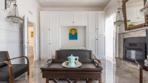 A room with a bed, a coffee table with a teapot, and a fireplace. - 2448 Palazzo Montagna - Suite by Barbarhouse (Melissano)