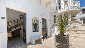 A white building with a balcony, a potted plant, and a bench. - 2448 Palazzo Montagna - Suite by Barbarhouse (Melissano)