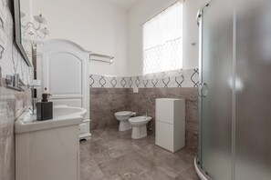 A modern bathroom with a white vanity, a glass shower enclosure, and a toilet with a bidet attachment. - 2448 Palazzo Montagna - Suite by Barbarhouse (Melissano)