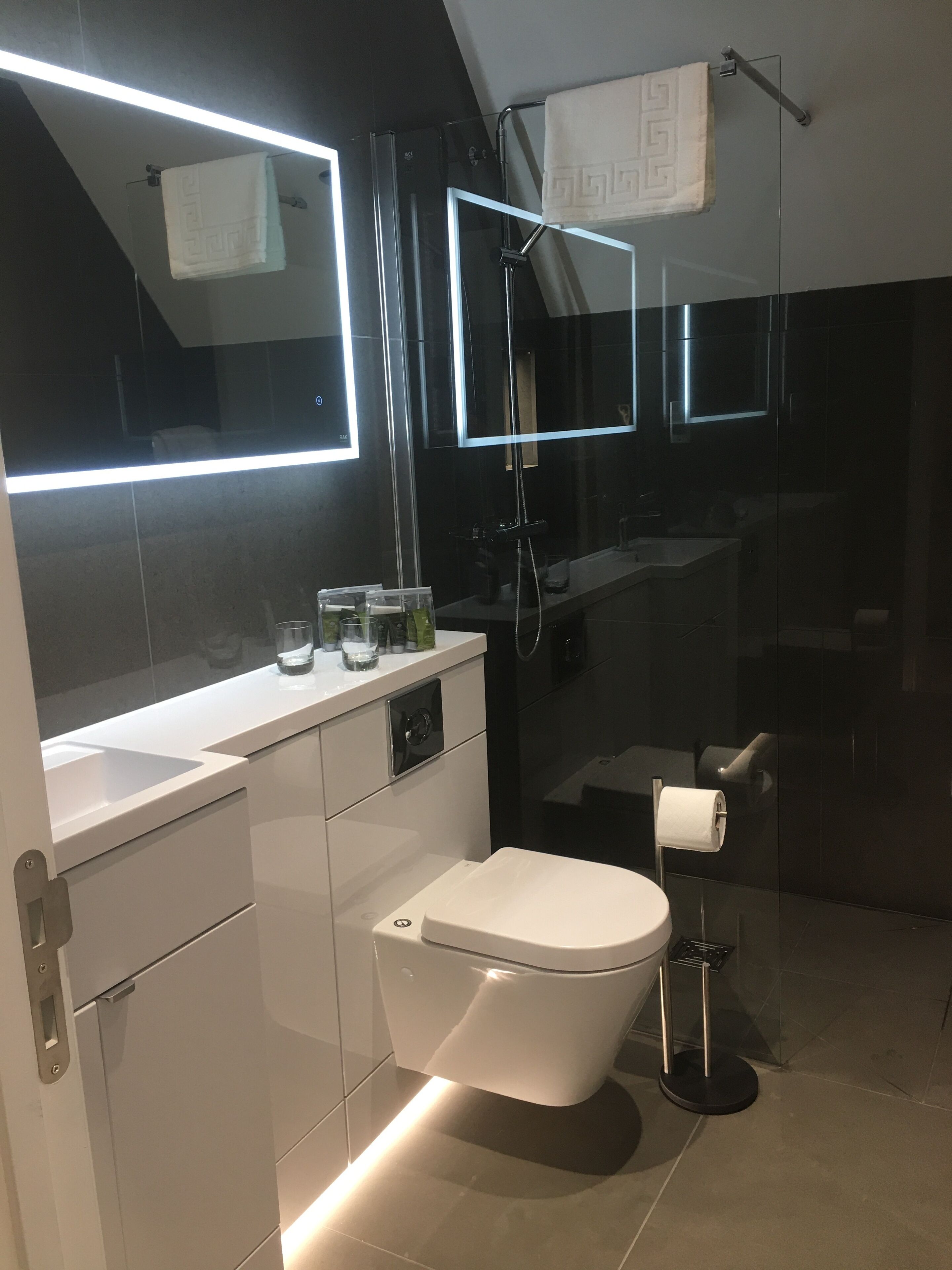 Un baño moderno con inodoro, lavabo y cabina de ducha de vidrio.
