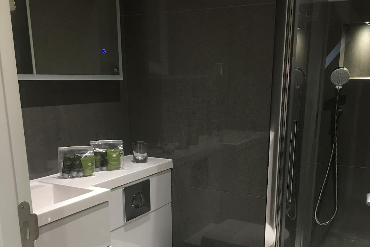 A modern bathroom with a toilet, sink, and shower.