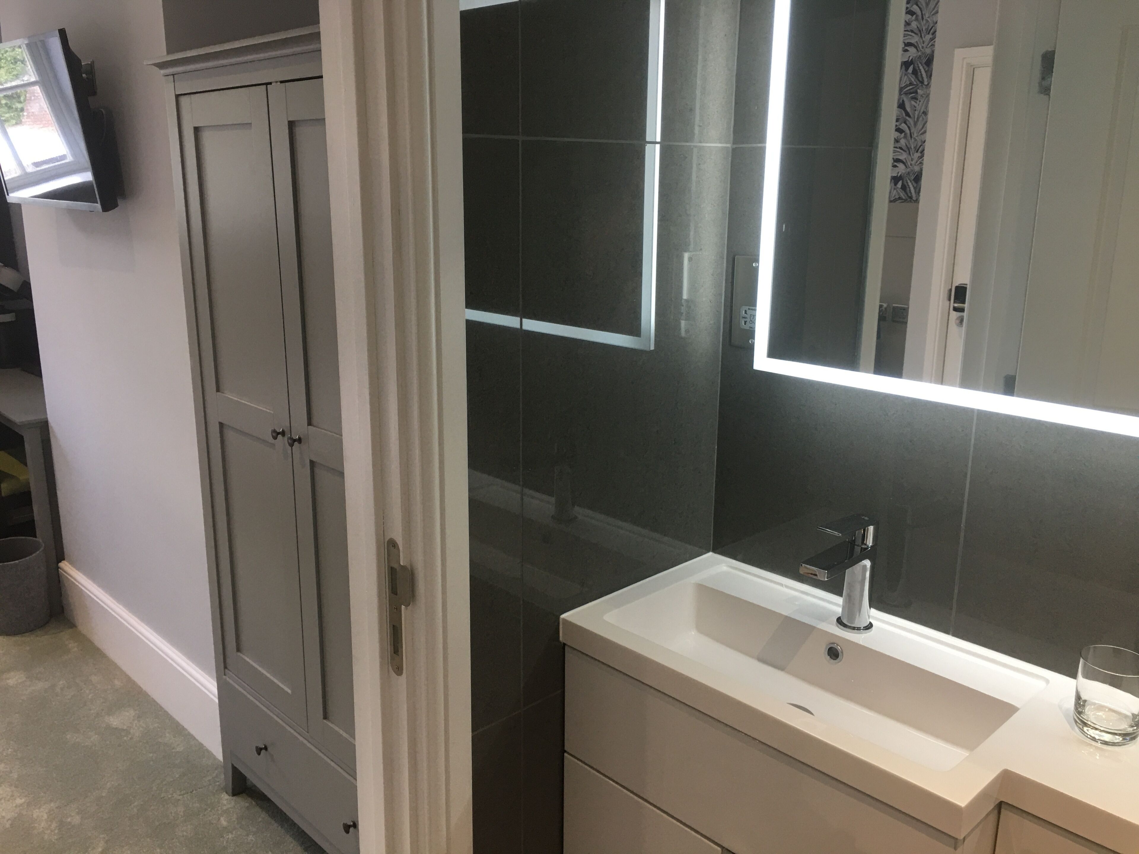 A bathroom with a white sink, a mirror, and a cabinet.