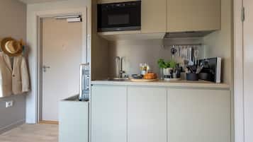 Una cucina moderna con forno a incasso, lavello e diversi utensili da cucina.