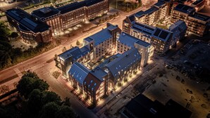 An aerial view of a modern building complex with multiple high-rise structures, a central courtyard, and surrounding roads. - Unity Malmö - A Studio Hotel (Malmö)