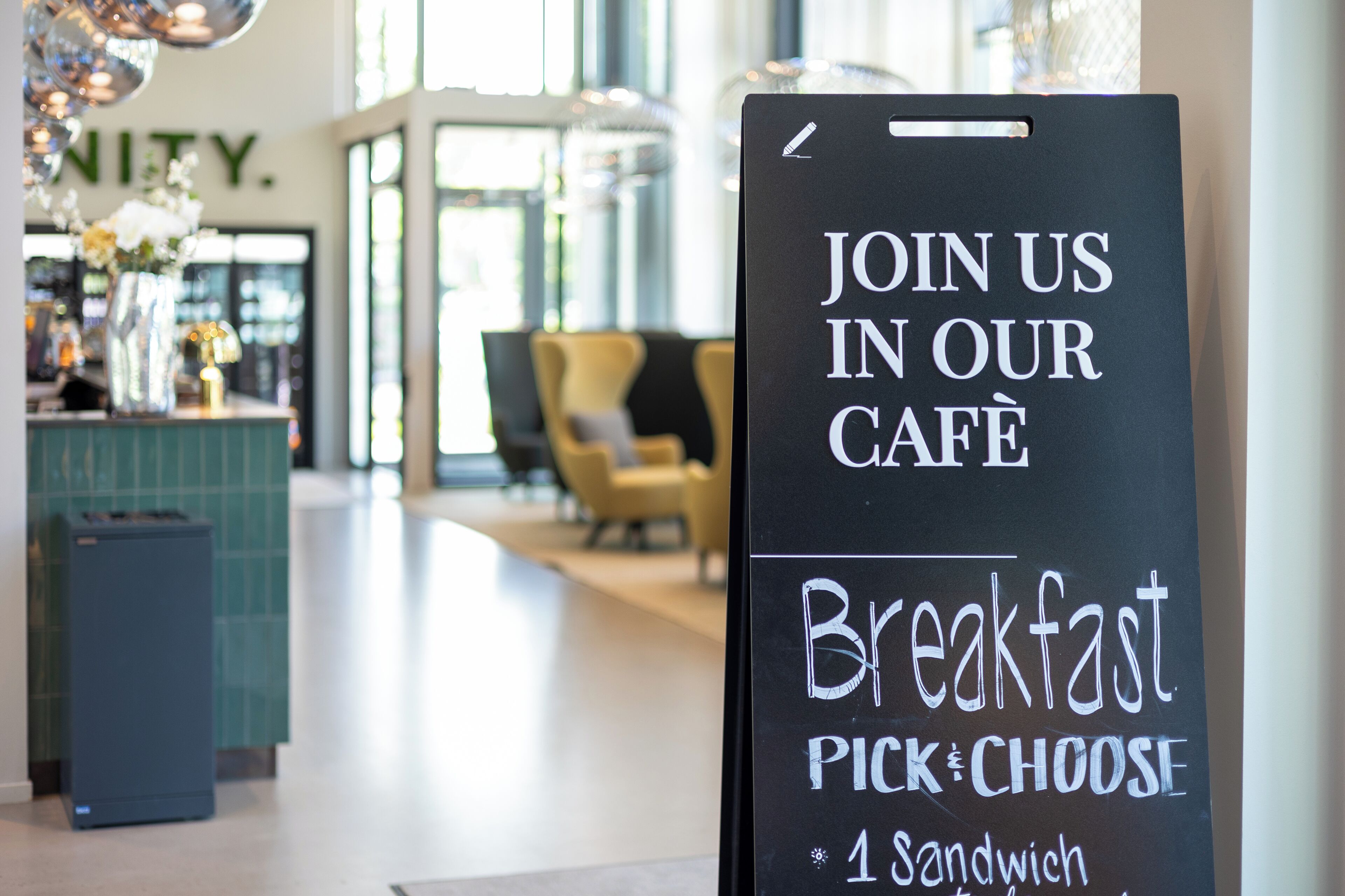 Letrero en una cafetería que anuncia desayuno con una selección de 4 sándwiches.