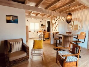 Un salón amplio con sofá, sillas y mesa de comedor.