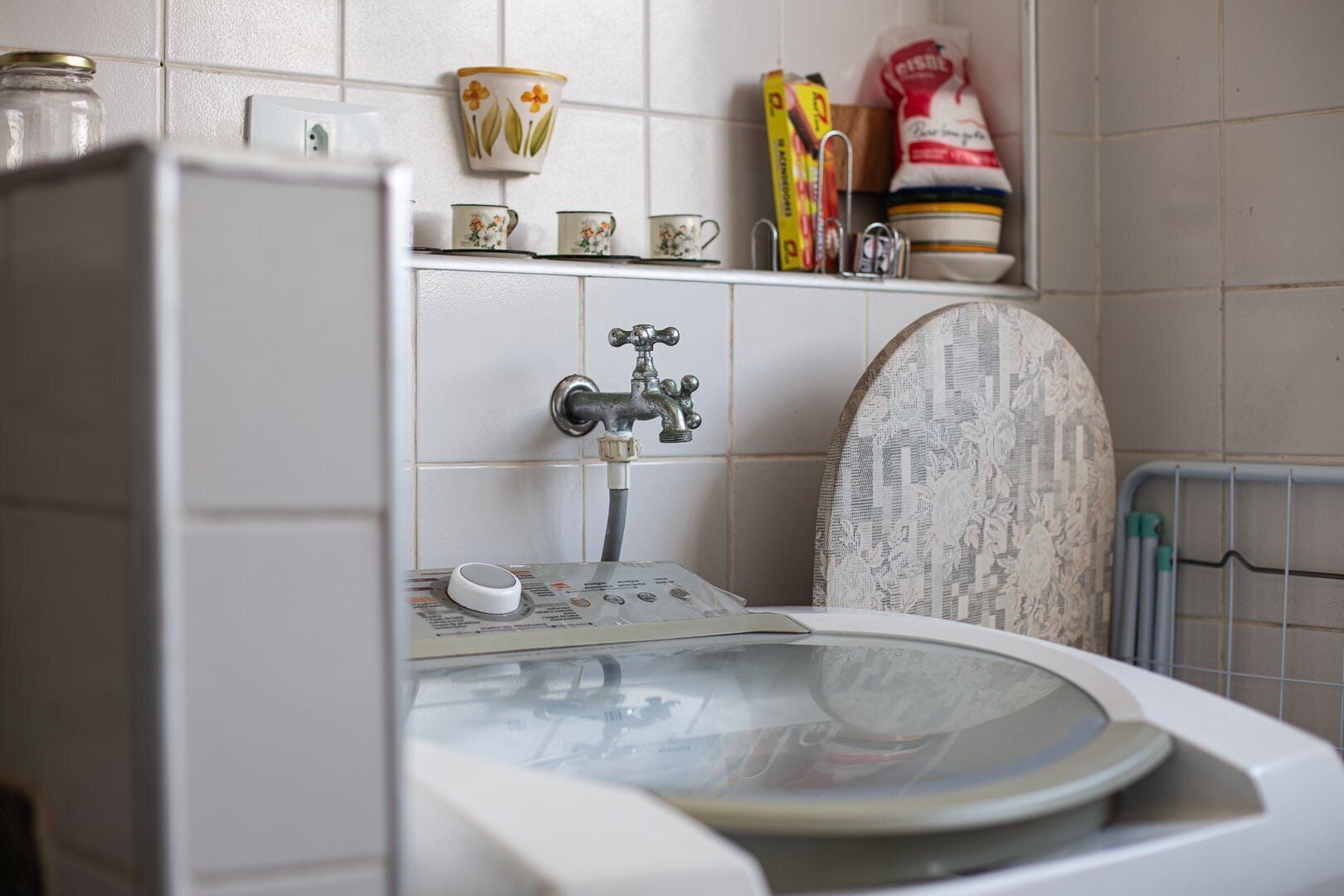 Ein Badezimmer mit Toilette, Dusche und Waschbecken. An den Wänden befinden sich Dekorationen und ein Ablagebereich mit Pflegeprodukten.