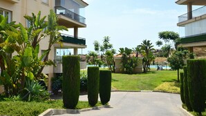 Un immeuble résidentiel doté de balcons, d’une piscine et de jardins bien entretenus.