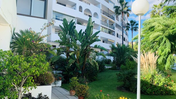A multi-story hotel with balconies, surrounded by lush greenery and a well-maintained garden. - Walking Distance to beach Torreblanca Rio Sol (Fuengirola)
