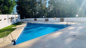 A rectangular swimming pool with a white deck, surrounded by potted plants and a white wall. - Walking Distance to beach Torreblanca Rio Sol (Fuengirola)