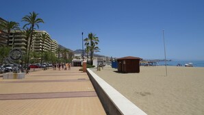 A beachside promenade with palm trees, a small wooden structure, and a hotel named "ARROYO". - Walking Distance to beach Torreblanca Rio Sol (Fuengirola)