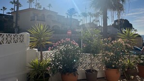A hotel with a white facade, palm trees, and potted plants in the foreground. - Wyndham Resort 4 Bed House (Mijas Costa)