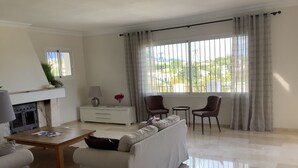 Un salon moderne avec une cheminée, un canapé, une table basse et deux fauteuils.