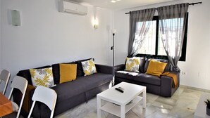 A modern living room with two grey sofas, white coffee table, and a floor lamp. - Pueblo Torrequebrada, Benalmadena 2 Bed Apt (Benalmádena)