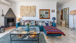 Ein Wohnzimmer mit Sofa, Couchtisch, Kamin und einem großen Spiegel.