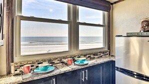 A kitchen with a view of the ocean through a large window, a stainless steel refrigerator, and a welcome sign. - Oceanfront Daytona Beach Condo w/ New Pool! (Daytona Beach)