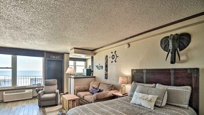 A bedroom with a large bed, a chair, a sofa, and a view of the ocean. - Oceanfront Daytona Beach Condo w/ New Pool! (Daytona Beach)
