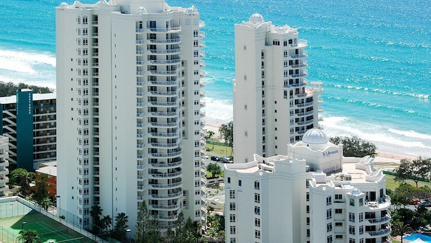 Un hôtel de grande hauteur doté de nombreux balcons, d’une piscine et offrant une vue sur l’océan.