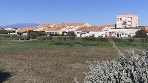 Zona residencial com casas, um campo e montanhas ao longe.