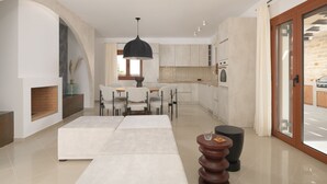 Ein modernes Wohnzimmer mit Kamin, Essbereich und einer Küche mit Schiebeglastüren.