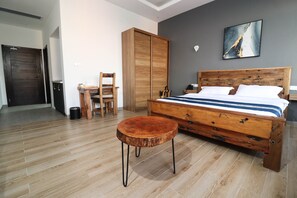 Cozy retreat with a comfortable bed, wooden table, and wardrobe.