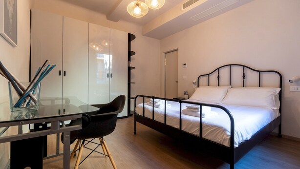 A bedroom with a bed, a desk, and a chair. - Italianway - San Vitale 87 (Bologna)