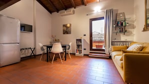 A compact living space with a kitchen, dining area, and a sofa. - Italianway - Piella 5 (Bologna)