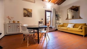 A cozy living room with a dining area, a yellow sofa, and a large mirror. - Italianway - Piella 5 (Bologna)