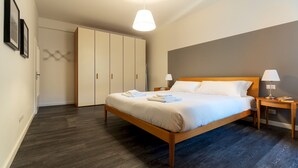 A neatly arranged bedroom with a bed, bedside tables, a wardrobe, and a hanging light fixture. - Italianway - Baracca 7 A (Bologna)