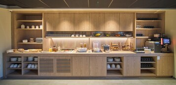 Cozinha bem organizada com armários de madeira, cafeteira e diversos utensílios e eletrodomésticos.