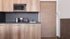 A modern kitchen with wooden cabinets, a microwave, a kettle, and a toaster. - Ciuk 11 (Valdisotto)