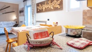 Una cucina accogliente con zona pranzo, un tavolo di legno e un cesto con tessuto a quadri.