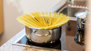 Una pentola di spaghetti crudi su un fornello.