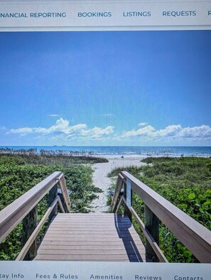 A beach view with a wooden walkway leading to the water. - Oceanfront Cocoa Beach Complex -3 min walk to beach (Cocoa Beach)