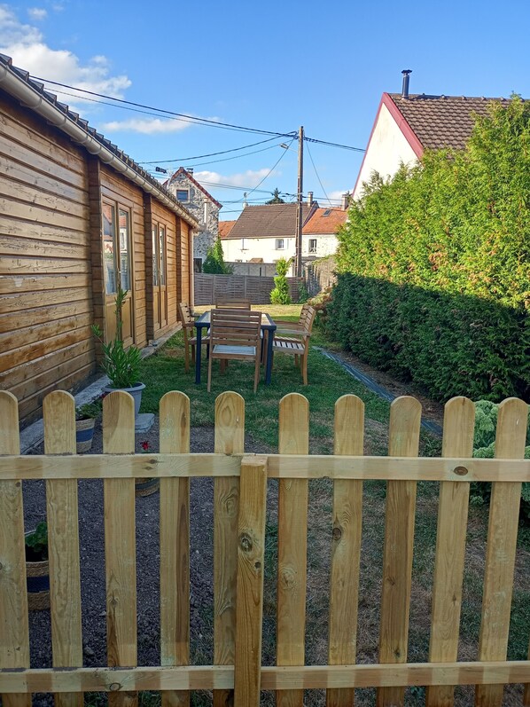 A wooden fence with a garden area in front. - The "Chalet" in the countryside just outside Paris (Tancrou)