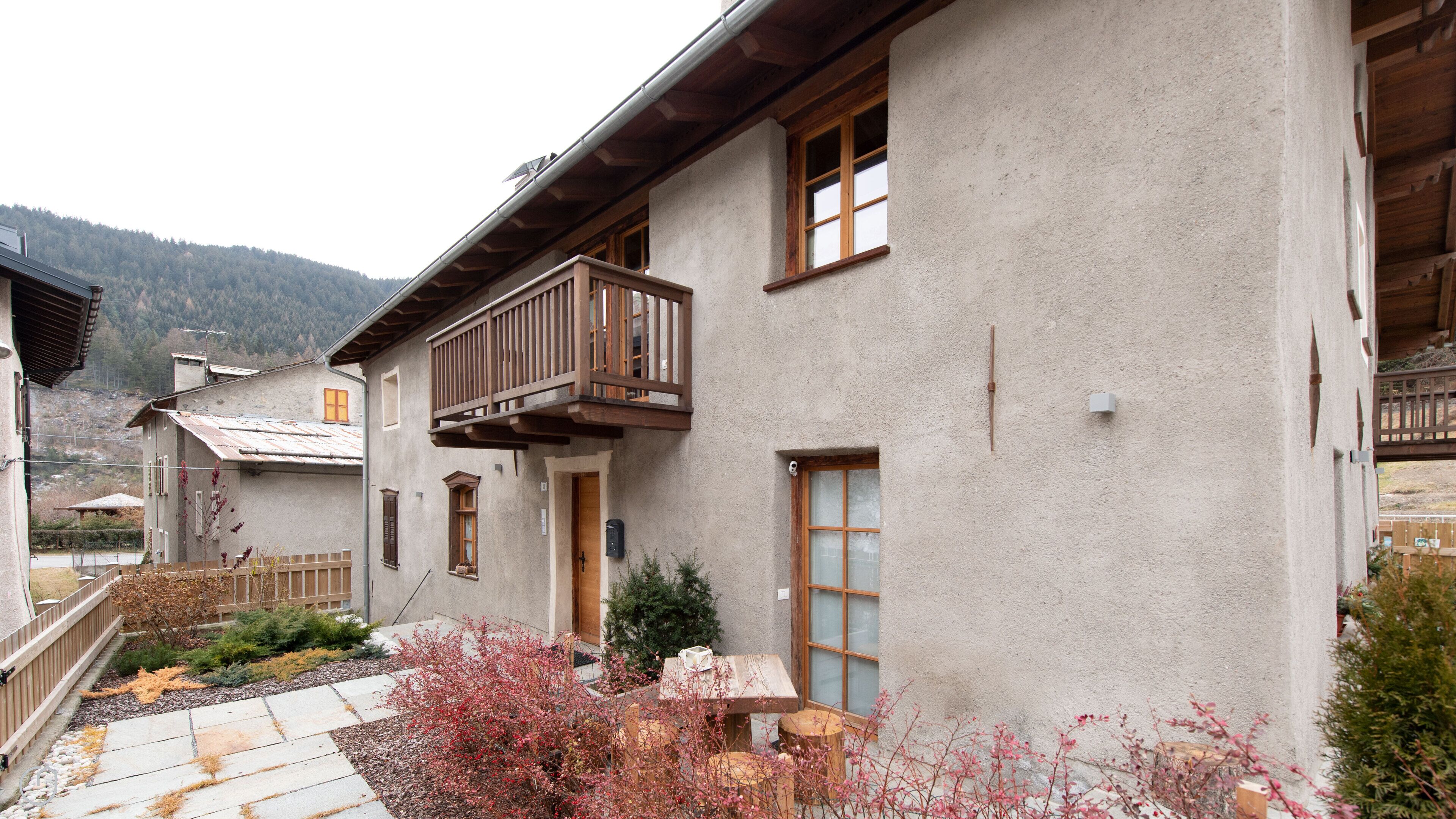 A two-story building with a balcony, a wooden door, and a window.