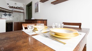 A dining table set with yellow plates, clear glasses, and a fork on a white placemat. - Sertorelli 2 (Bormio)