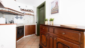 A kitchen with wooden cabinets, a stove, and a tiled backsplash. - Sertorelli 2 (Bormio)