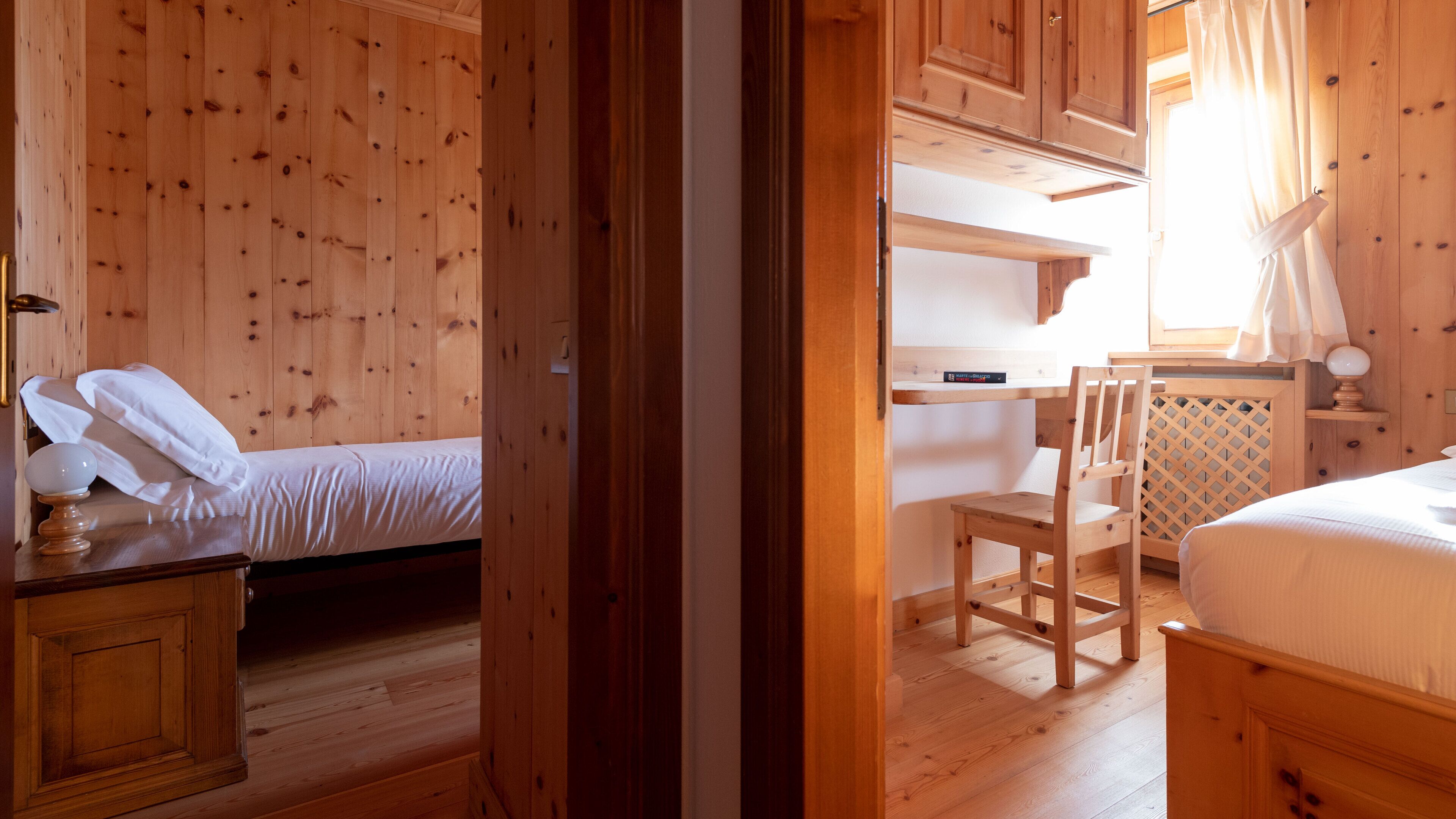 Une pièce de cabane en bois comprenant un lit, une chaise et une petite table.