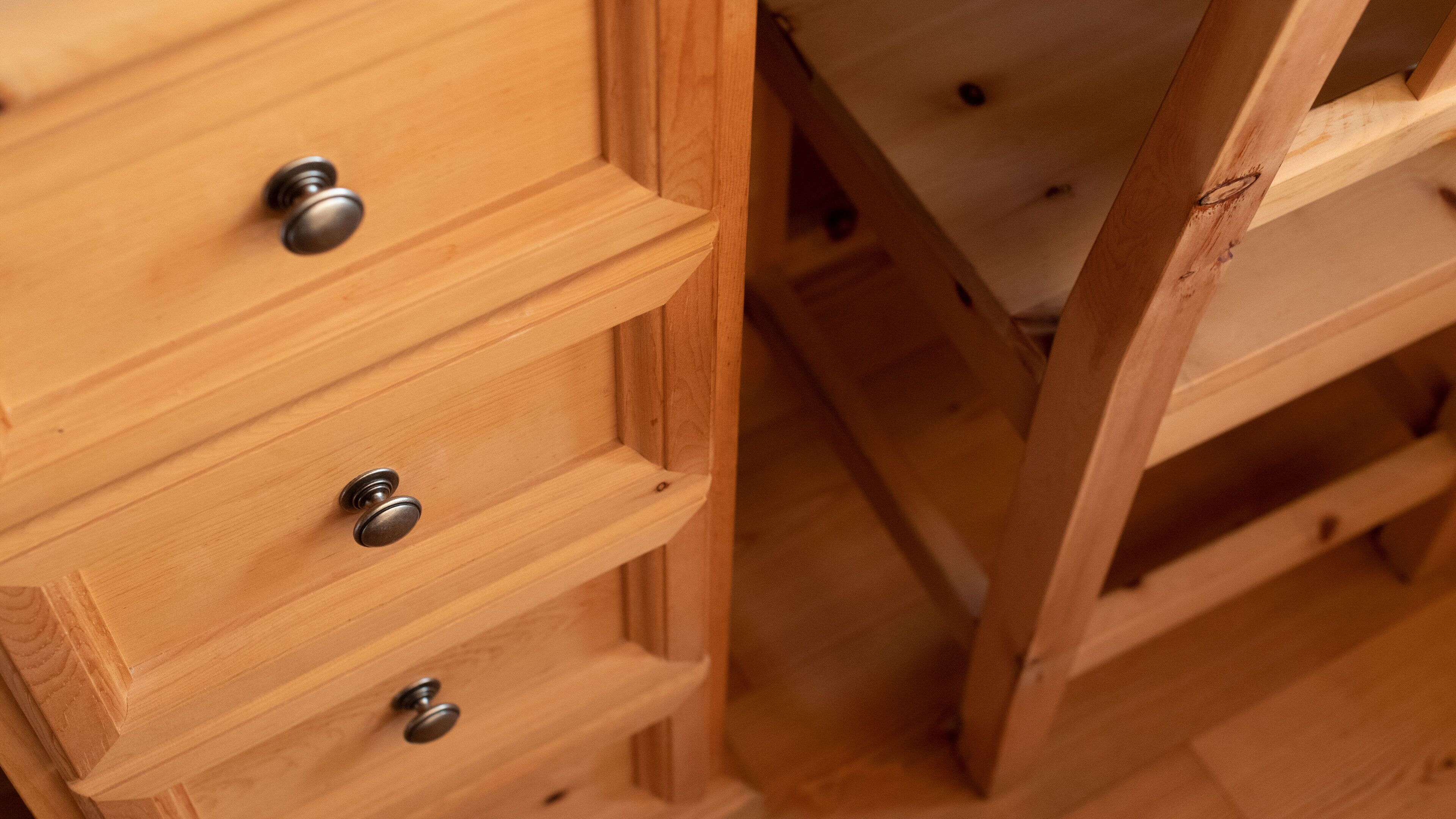 Primer plano de cajones de madera con tiradores metálicos, parte de una estructura de madera más grande.