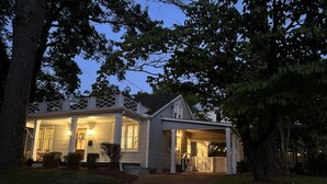 A two-story house with a covered porch and a front entrance. - Luxury Home - Walk to Grove and Square - Outdoor Patio Seating (Oxford)