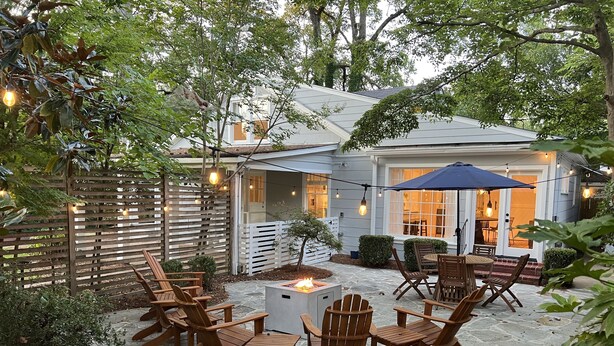 A patio with stone flooring, wooden chairs, a fire pit, and string lights. - Luxury Home - Walk to Grove and Square - Outdoor Patio Seating (Oxford)