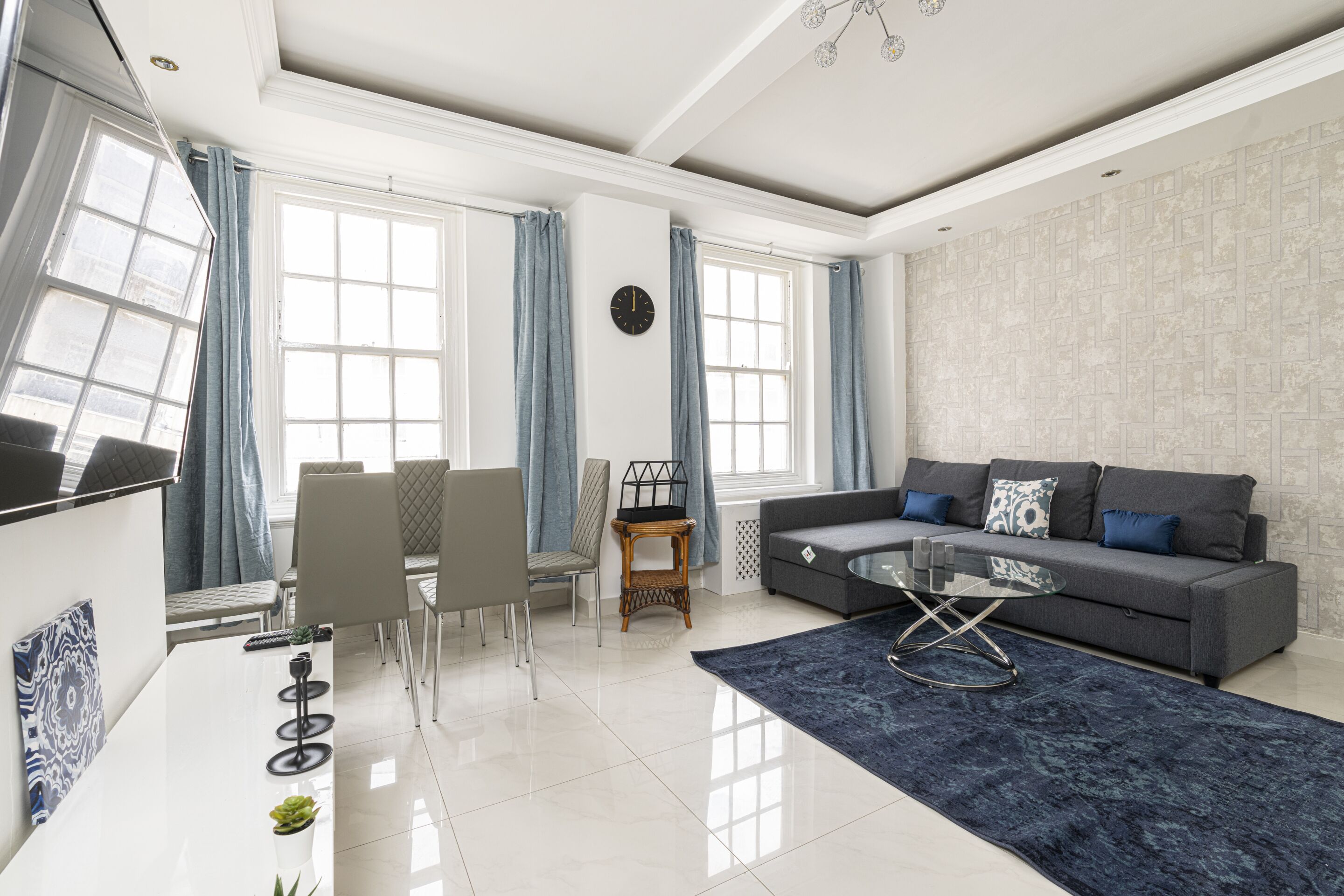 A modern living room with a sofa, coffee table, and dining area.