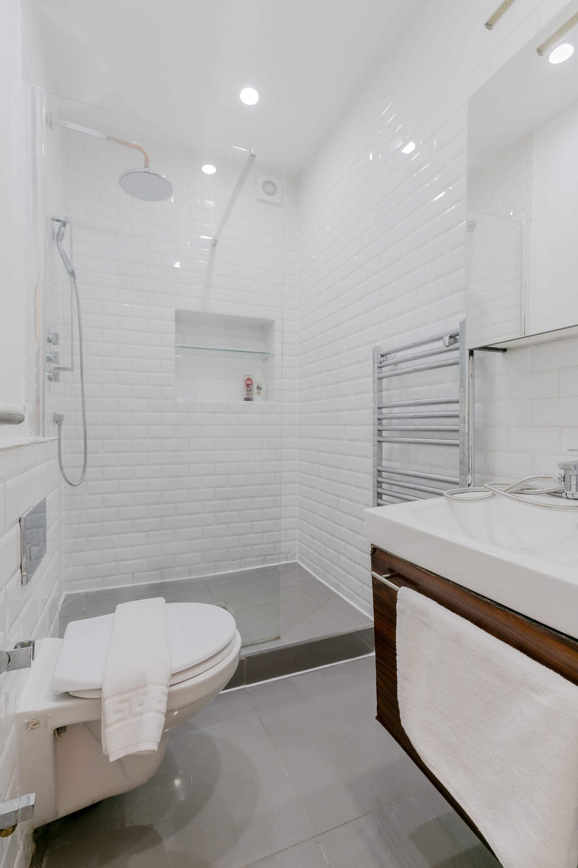 A modern bathroom with a toilet, shower, and vanity.