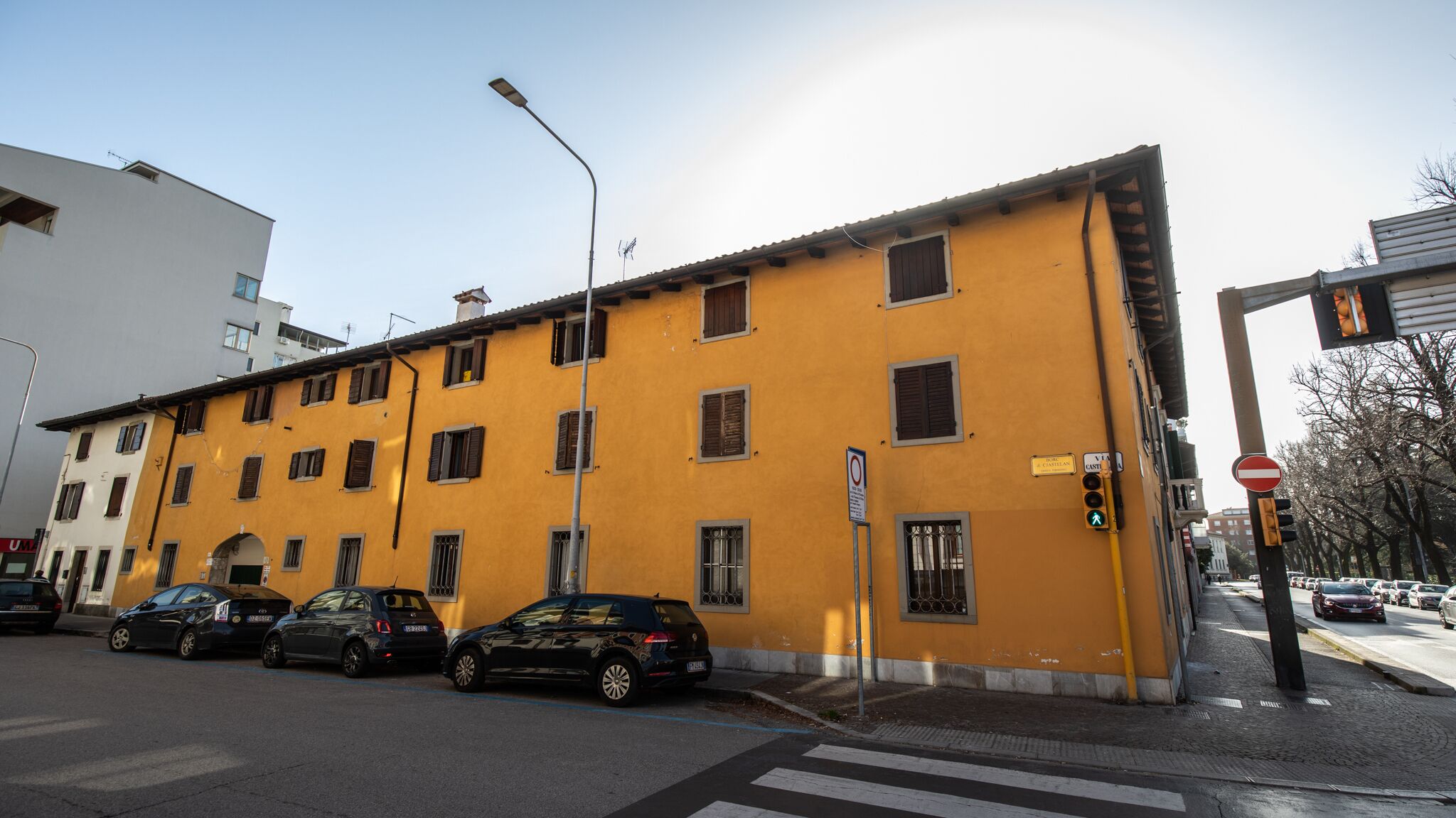 Ein gelbes Gebäude mit zahlreichen Fenstern und einer Straße davor.