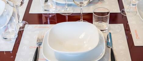 Una mesa con un plato blanco, un cuchillo y un tenedor sobre un mantel individual con el logotipo de Italianway.