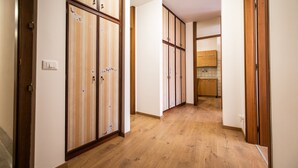 A hallway with wooden flooring and sliding doors with floral patterns. - Italianway - Aquileia 53 (Udine)